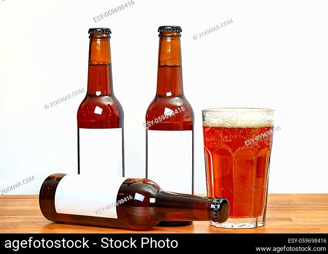 Four beer bottles with blank labels on a table