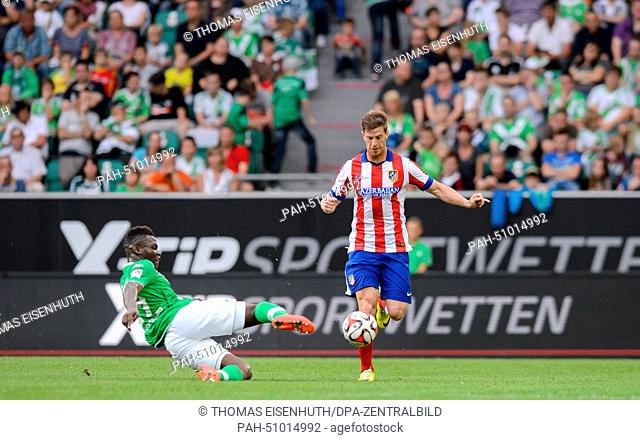 Wolfsburg's Junior Malanda (L) and Madrid's Cristian Ansaldi in action during the soccer test match between VfL Wolfsburg and Atletico Madrid at Volkswagen...