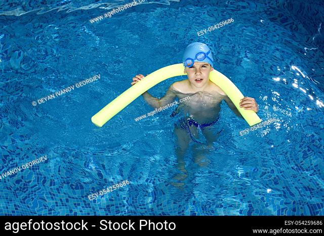 Little boy in swimming pool. Blue swimming pool