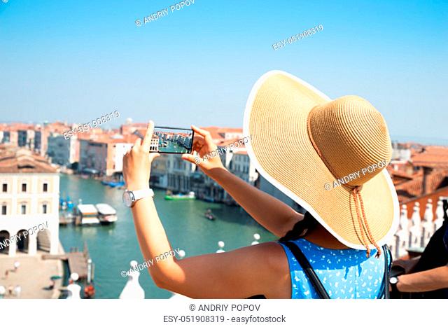 Rear View Of A Female With Smart Phone Takes Pictures In Venice Italy