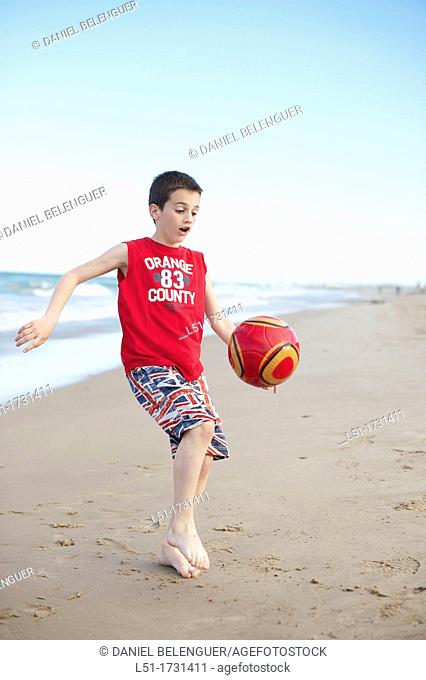 Boy playing football at the beach, El Saler beach, Albufera de Valencia Nature Reserve, Spain, Valencia