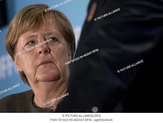 22 October 2018, Hessen, Ortenberg: Chancellor Angela Merkel (CDU) is standing in the marquee on the cold market. A new state parliament will be elected in...