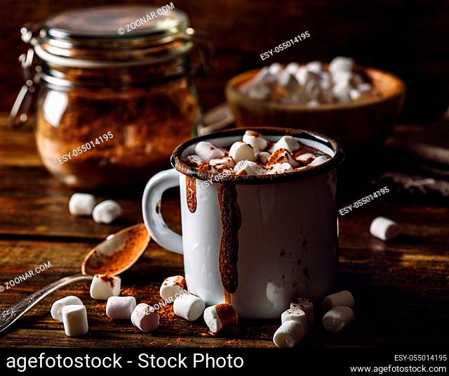 Dirty Mug of Cocoa with Marshmallow. Jar of Cocoa Powder and Marshmallow Bowl on Backdrop