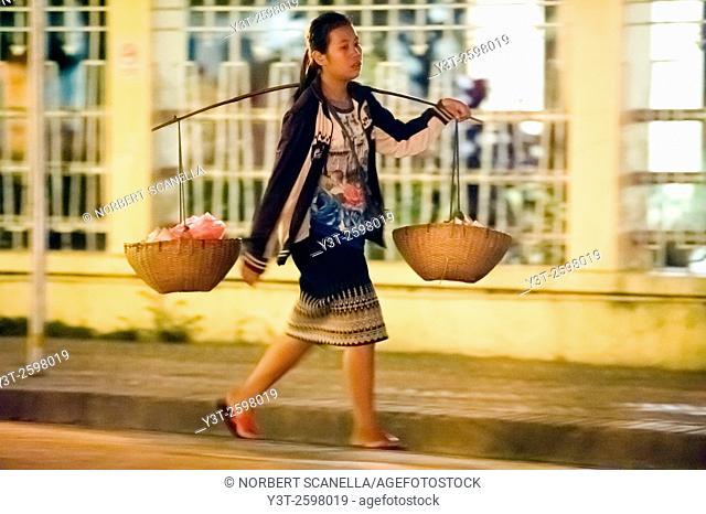Asia. South-East Asia. Laos. Province of Luang Prabang, city of Luang Prabang, World heritage of UNESCO since 1995. Woman carrying baskets