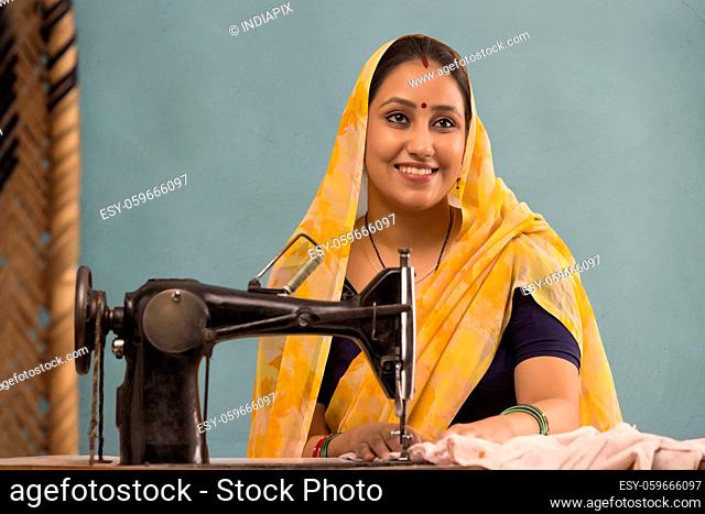 A woman smiling with a sewing machine