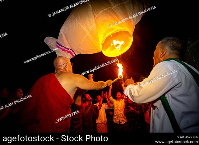 Bangladesh - October 13, 2019: A Buddhist monk with his disciples trying to fly a paper lantern at Ujani Para Buddhist Temple in Bandarban, Bangladesh