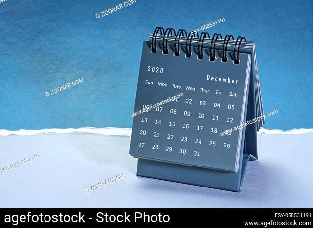 December 2020 - spiral desktop calendar against paper landscape abstract, time and business concept