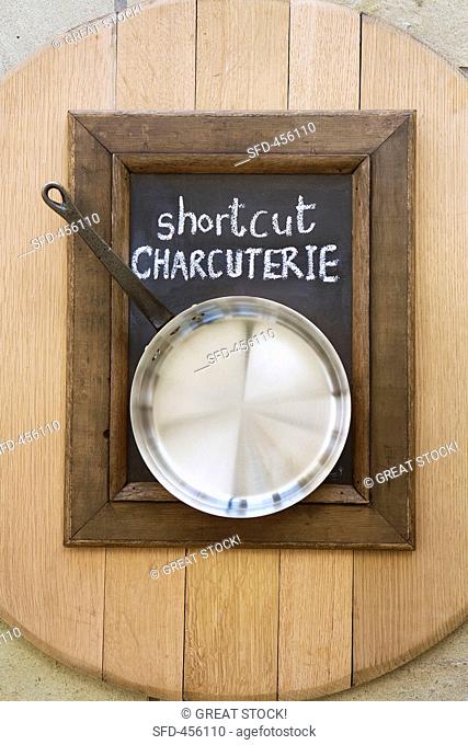 A saucepan on a blackboard with a wooden frame