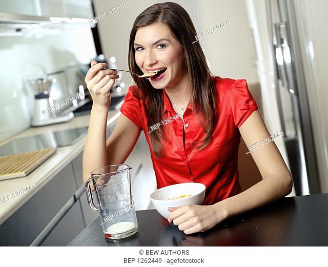 Woman eating corn flakes with milk