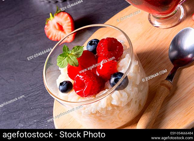 delicious milk rice with different berries and red fruit jelly
