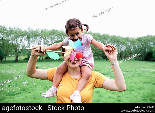 Mother and daughter playing with pinwheel at park