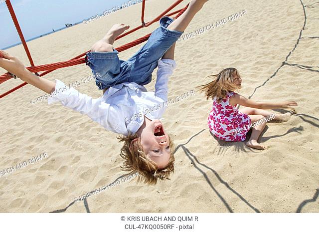 Boy playing on ropes on beach
