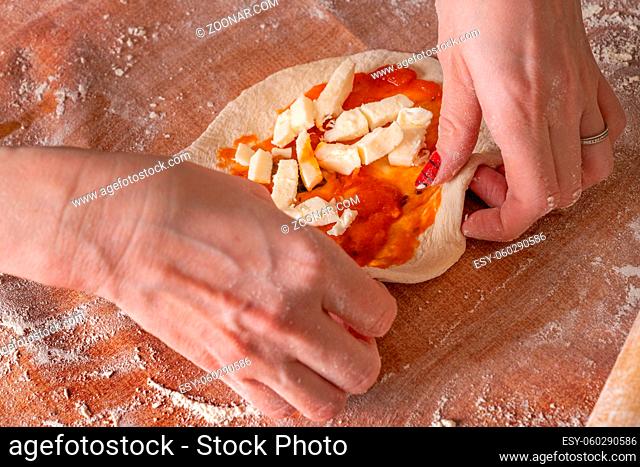 Making dough by female hands brown table background, view from above