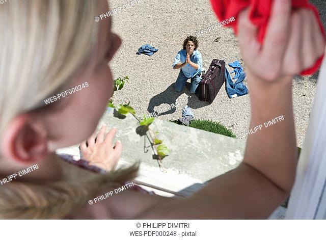 Italy, Tuscany, View of guilty young man with luggage from hotel window