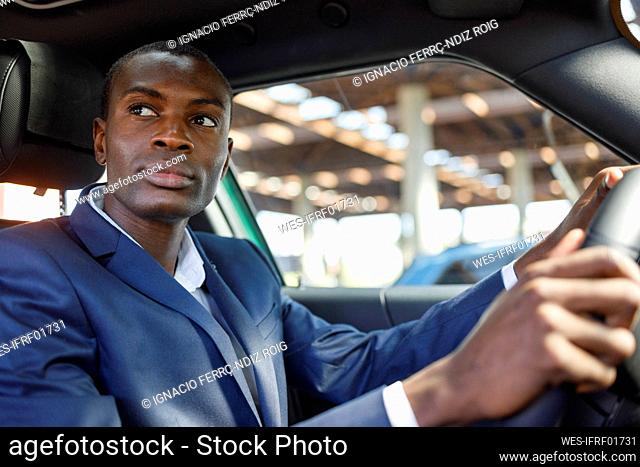 Thoughtful young businessman driving car