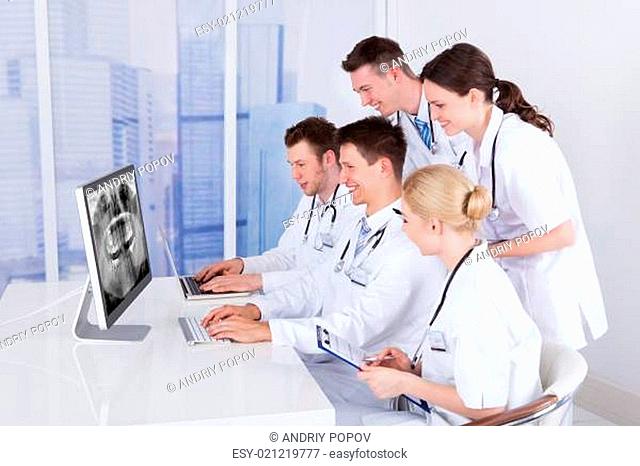 Dentists Examining Jaw Xray On Computer