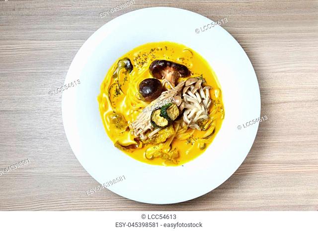 Linguini with fungus, wild mushroom and pumpkin sauce on wooden table