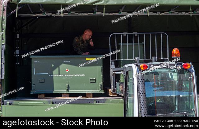 08 April 2020, Saxony-Anhalt, Blankenburg: A forklift truck loads boxes with X-ray equipment onto the trailer of a Bundeswehr truck at the Bundeswehr Medical...