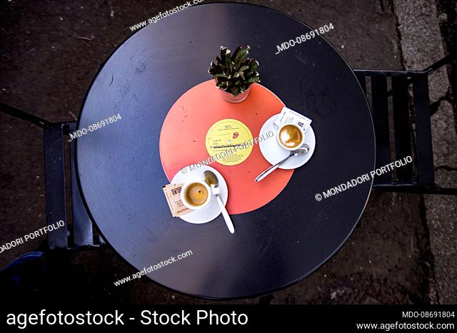 Two cups of coffee on a vinyl-shaped table. Rome (Italy), March 1st, 2021