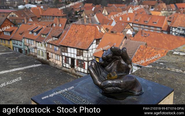 16 March 2021, Saxony-Anhalt, Quedlinburg: Two hands symbolically protect a house. The monument was erected on the Schlossberg in honour of the German...