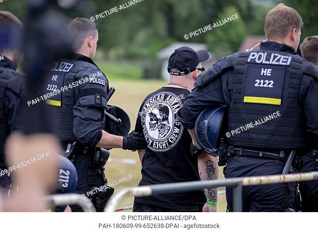 09 June 2018, Germany, Themar: Police officers lead away a festivalgoer from the site of the right-wing festival ""Tage der nationalen Bewegung""