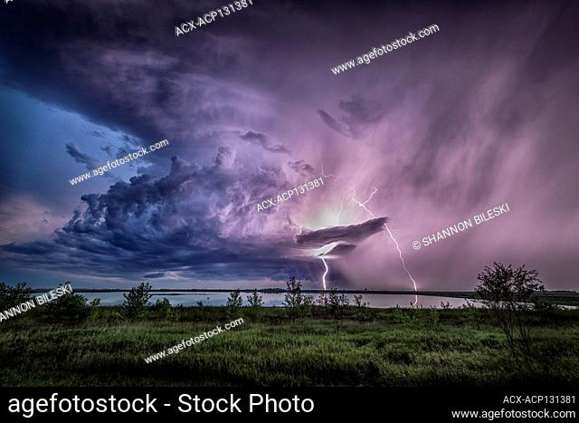 Storm with lightning reflecting off lake in rural North Dakota United States
