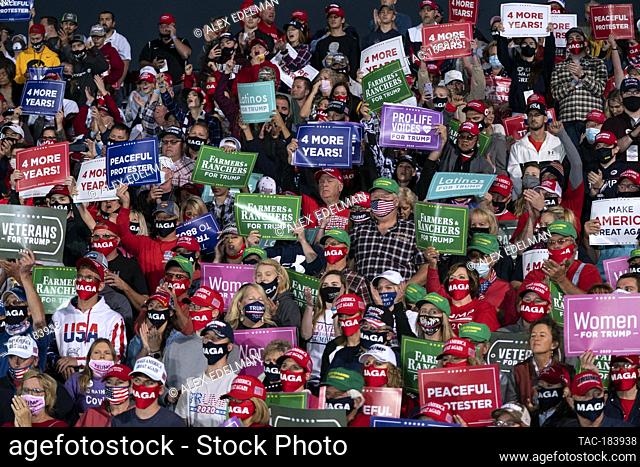 Supporters listen as US President Donald Trump speaks during a Make America Great Again campaign event at Des Moines International Airport on October 14