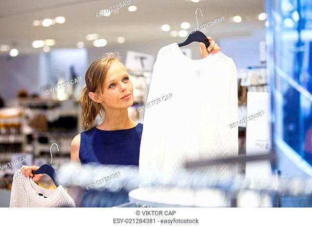 Pretty, young woman choosing the right light for her apartment in a modern home furnishings store (color toned image shallow DOF)
