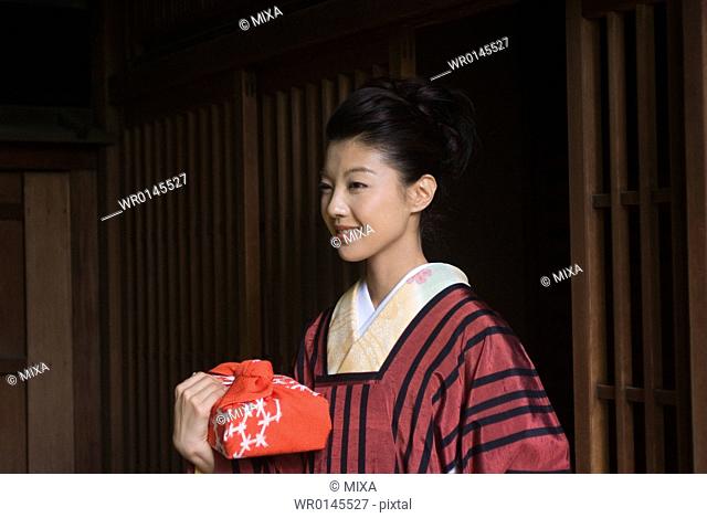 Young woman in kimono opening door
