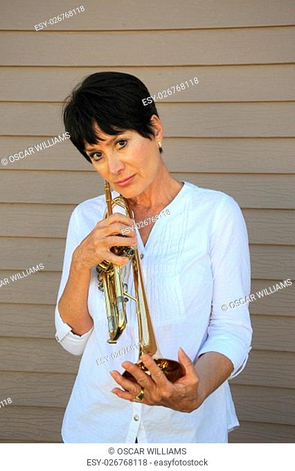 Mature female beauty holding her trumpet outside