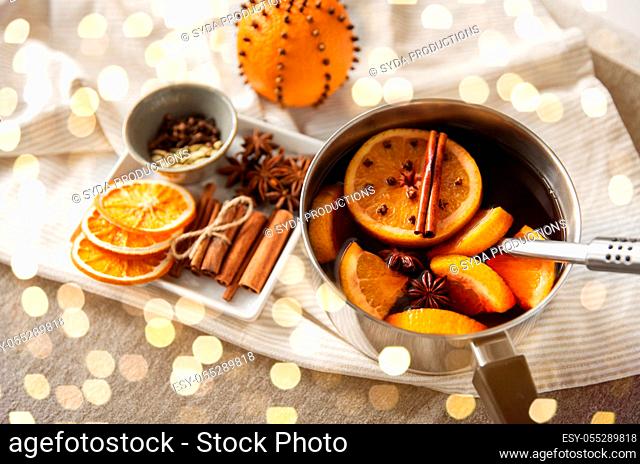 pot with hot mulled wine, orange slices and spices