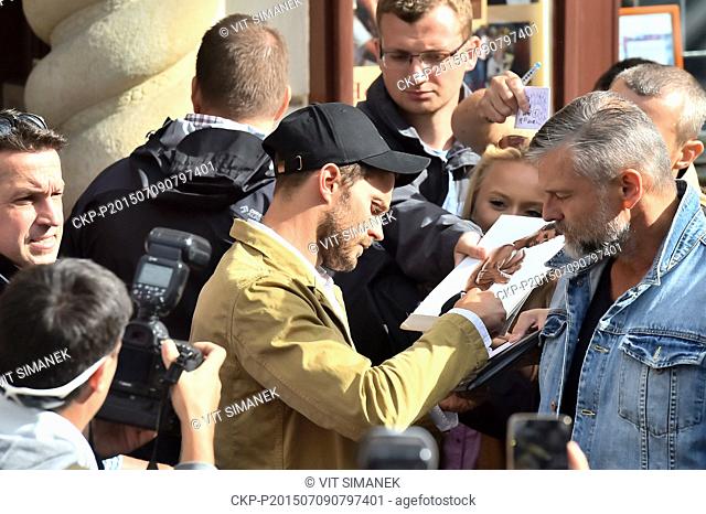 Irish actor and musician Jamie Dornan, center with cap, signs his autograph for fans at the 50th International Film Festival in Karlovy Vary, Czech Republic