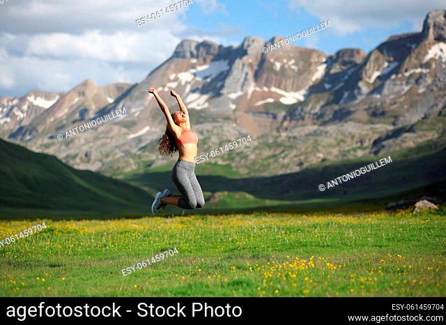 Full body portrait of a runner jumping in a high mountain