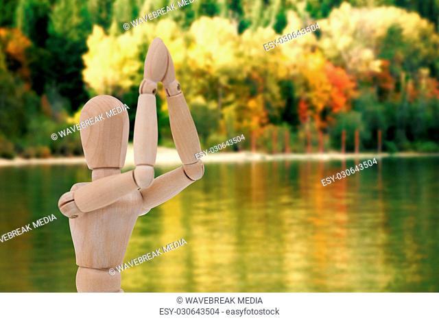 Composite image of wooden figurine standing with both the hands joined