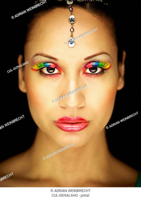 Young woman with jewel head accessory and coloured eyelashes