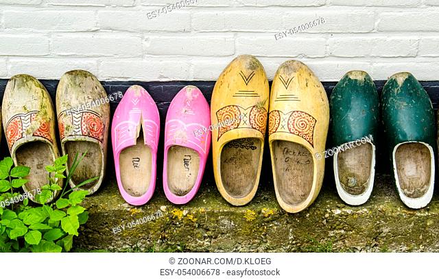 Several Dutch wooden shoes against a black and white wall