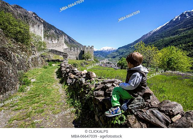 Child observes Visconti Venosta Castle. Grosio. Province of Sondrio. Valtellina. Lombardy. Italy. Europe