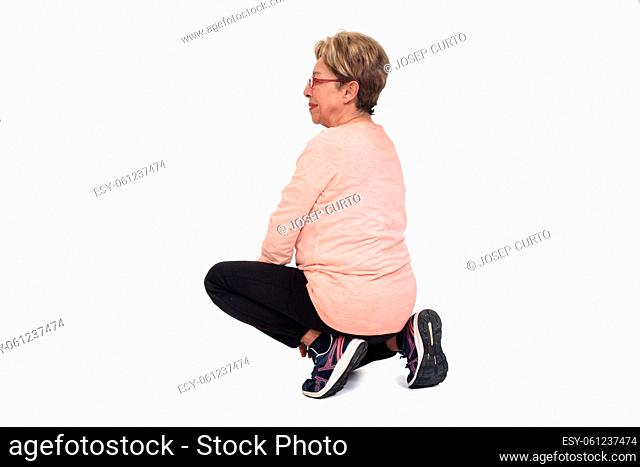 side view of a senior woman squatting on white backgrond