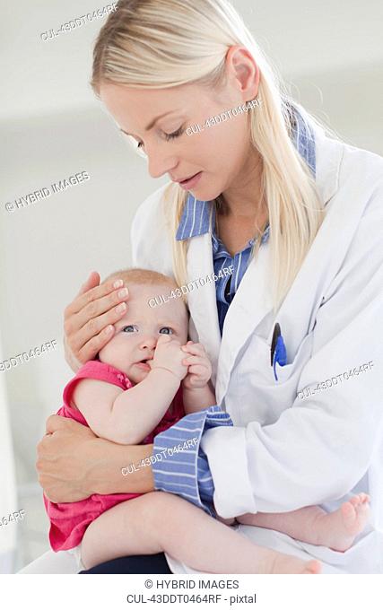 Doctor hugging crying baby