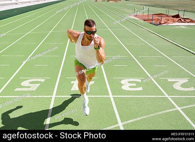 Determined athlete running at sports field