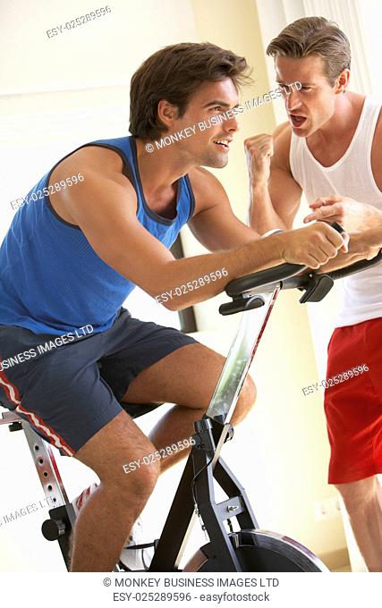 Young Man On Exercise Bike With Trainer