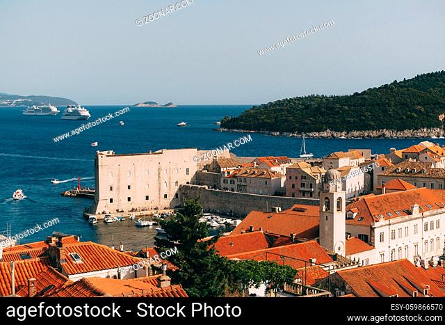 View of the fort on the wall, Lokrum island and moored boats near the city walls. The old port harbor is porporela, near the walls of the old town of Dubrovnik
