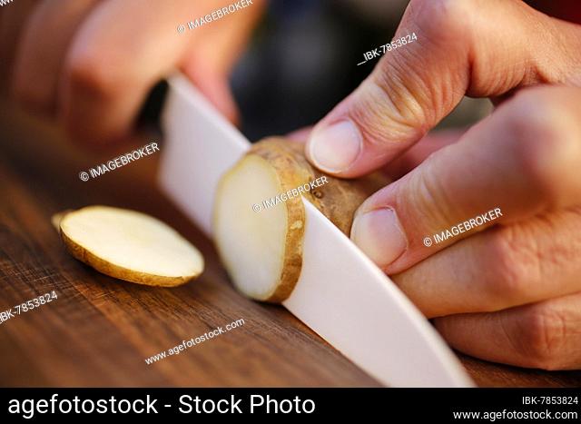 Baden cuisine, jerusalem artichoke (Helianthus tuberosus), earth apple, earth pear, cutting tubers, men's hands, knife, wooden board, Germany, Europe
