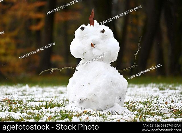 26 November 2023, Bavaria, Munich: A little snowman stands on a meadow in the English Garden. Photo: Katrin Requadt/dpa. - Munich/Bavaria/Germany