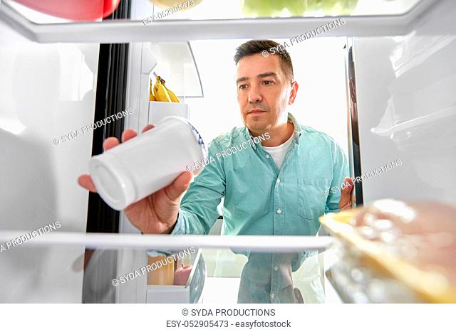 man taking food from fridge at kitchen