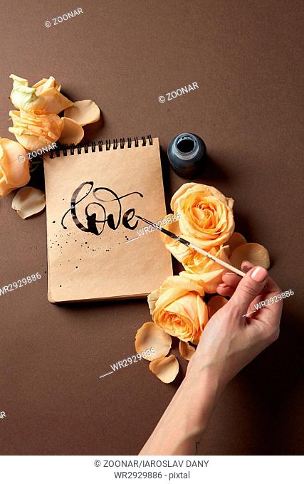 Hand with brush writing a love letter