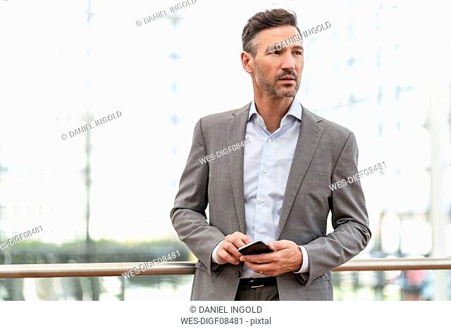 Portrait of businessman holding cell phone
