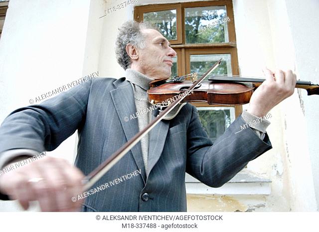 Russia. 2003. Former music teacher has to play on the street