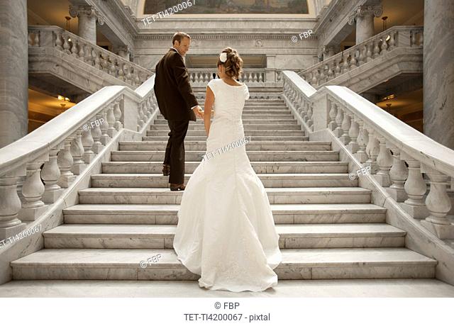Bride and groom holding hands on steps