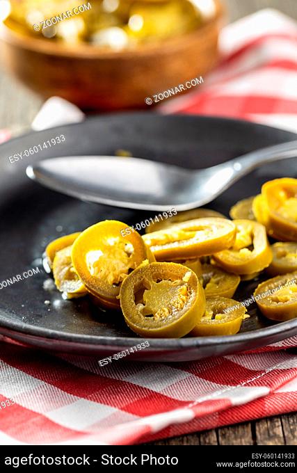 Pickled sliced jalapeno. Green jalapeno peppers on plate